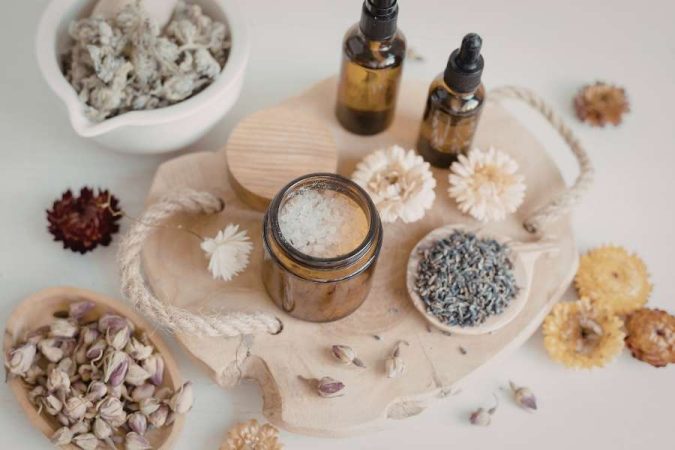 Ingrédients naturels disposés sur un plateau avec huiles essentielles, fleurs séchées et sel de bain
